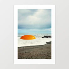 Load image into Gallery viewer, Beach Egg surreal collage wall art print featuring a giant golden egg yolk resting on a sandy shoreline with waves and rocks, blending food culture with coastal landscapes. Perfect quirky artwork for kitchens, cafes, diners, or beach house interiors. This surreal art print adds playful imagination to modern gallery walls, breakfast nooks, or creative home decor ideas. Ideal for art lovers, surreal collage fans, and anyone searching for unique conversation-starting wall posters.