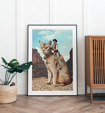 Load image into Gallery viewer, Cat Lone Ranger artwork featuring a cowboy riding a giant cat through a desert landscape, perfect for quirky and unique home decor, rodeo art and western desert interior design adds a playful touch to any room. Enhance your home decor with this imaginative and humorous print. Shop now for quirky wall art.