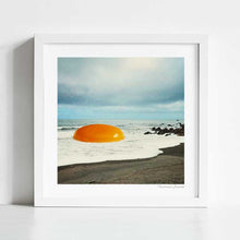 Load image into Gallery viewer, Explore 'Beach Egg,' a surreal collage artwork blending coastal scenery with whimsical charm. This piece features a giant golden egg yolk on a beach, perfect for art lovers and those intrigued by surrealism. Ideal for modern home decor and beach-themed collections, 'Beach Egg' captures attention with its surreal juxtaposition and imaginative visuals