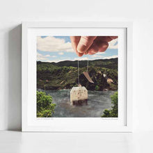Load image into Gallery viewer, “Lake Afternoon Tea” is a surrealist collage where landscape art meets cozy comfort, depicting a giant teabag steeping in a lake. Perfect wall décor for tea lovers, wellness seekers, and those who value self-care and relaxation. Works beautifully as kitchen art, dining room décor, or spa-inspired interiors. Great for quirky gallery walls, tea shops, and cafés. A whimsical and calming piece of art that celebrates afternoon tea, hot drinks, and treating yourself with a fresh brew.