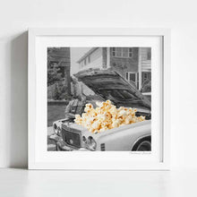 Load image into Gallery viewer, This surreal retro artwork, titled “Pop the Hood,” reimagines a vintage 1960s car with a popcorn-filled engine. The black and white photography contrasts with the warm tones of popcorn, creating a bold and witty poster. Ideal for kitchens, home theaters, or man caves, this artwork is a fun conversation starter for mechanics, popcorn fans, and retro art lovers. A unique black and white art print for those who love quirky, surreal wall decor with a mid-century kitsch aesthetic.